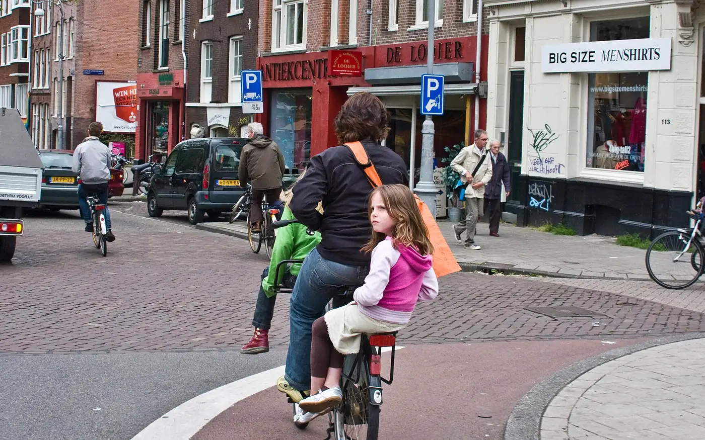 Mutter mit Kindern auf Rädern in der Stadt